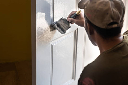 A painter coating both sides of a door near Petoskey and Harbor Springs, Michigan (MI)