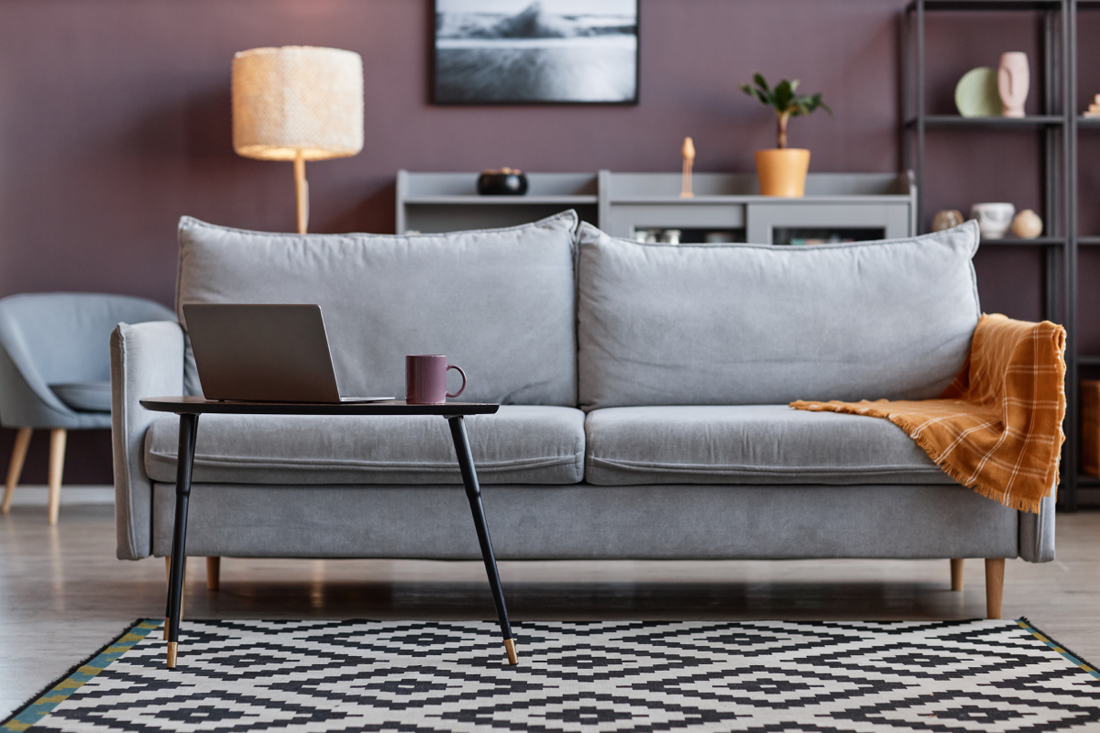 A living room with mauve walls and gray furniture